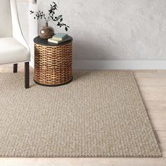 a white chair sitting next to a wicker basket on top of a wooden floor