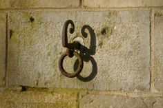 an old rusted metal hook on a brick wall with the number 8 attached to it