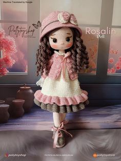 the doll is wearing a pink hat and dress