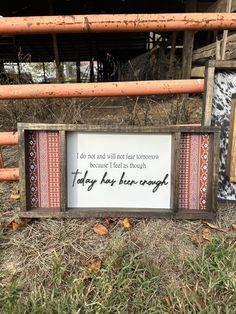 a sign that is on the ground in front of some sticks and grass with other items around it