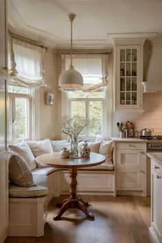 A breakfast nook with a built-in bench and cushions surrounds a small wooden round table, situated next to bright windows in a classic kitchen setting. Kitchen Nook With Round Table, Cute Country Home Decor, Eating Nook In Kitchen, Cozy English Home, Breakfast Cabinet, Cottage Style House Interior, Happy Future, Cozy Country Kitchen, Round Room Interior Design