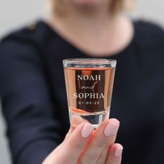 a woman holding a glass with the name noah and sophiia on it