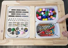 two trays filled with different types of crafting materials on top of a wooden table