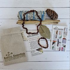 the contents of a beaded bracelet laid out on a white wooden table with pine cones