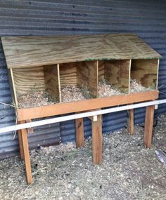 a wooden bench sitting in front of a building with some hay on top of it