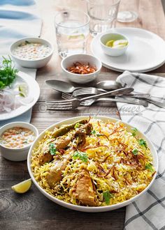 a bowl filled with rice and meat next to bowls of other food on a table