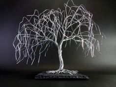 a wire tree sculpture sitting on top of a black table