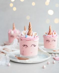 there is a cupcake with pink frosting and unicorn horns on it