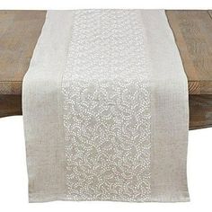 a white table runner on top of a wooden table