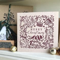 a christmas card sitting on top of a mantle next to other holiday decorations and ornaments