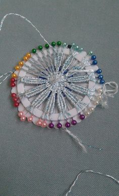 a white string and beaded decoration with multicolored beads