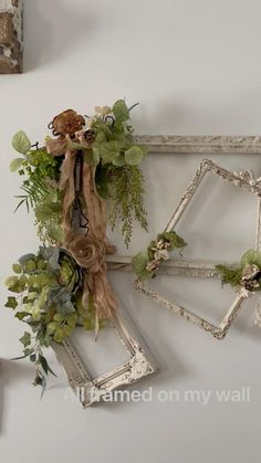 three frames with flowers and greenery hanging on the wall