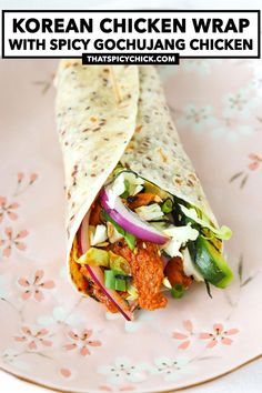 chicken wrap with spicy gochulang chicken on a pink and white floral plate