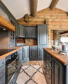 a kitchen with wooden floors and gray cabinets, an oven and counter tops in the center