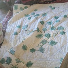 an unmade bed with green leaves on it