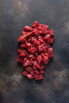 chopped up red meat on a black surface