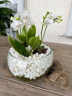 a glass bowl filled with rocks and flowers