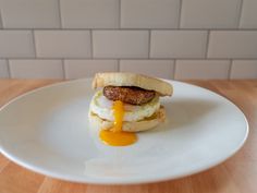 an egg and sausage sandwich on a white plate