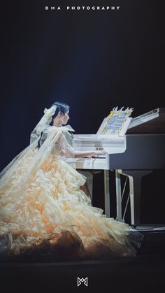 a woman sitting at a white piano in front of a black background with text that reads,