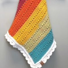 a multicolored crocheted dishcloth on a table