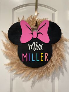 a minnie mouse door hanger with the words mrs miller on it and a pink bow