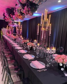 a long table is set up with pink and silver plates, candles, and flowers