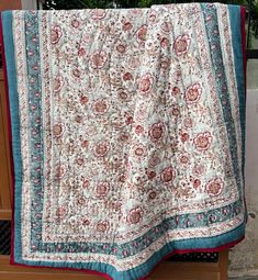 a white and blue blanket sitting on top of a wooden bench