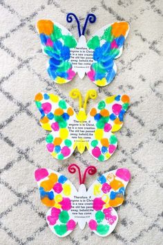 three butterflies made out of colored paper with words written on the wings and one has been cut