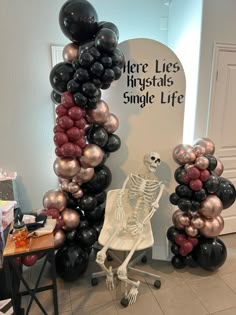 a skeleton sitting on a chair in front of a bunch of balloons that spell out there lies phystals single life