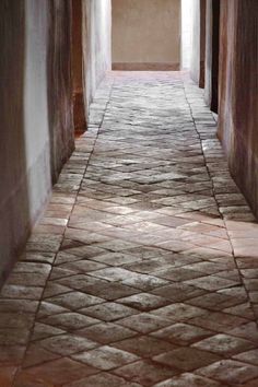 an empty hallway with tiled floor and walls