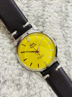 BRAND: HMT MODEL: SLIM DIAL: YELLOW DIAL CASE: STAINLESS STEEL CASE CASE SIZE: 35MM DIAMETER MOVEMENT: SIGNED MOVEMENT: MANUAL WINDING MOVEMENT CALIBER: 17JEWELS STRAP/BAND:TWO PIECE BAND STRAP  Country: MADE IN INDIA We ship watches within 3 to 4 days after payment/confirmation received. We check all watches once again after the sale to provide good service to my valuable clients, so it takes some time Old stock Unused watch Box available  MAYBE ANY ERROR IN DESCRIPTION FOUND HERE, NOT DELIBERATELY DONE TO MISLEAD BUYERS/VISITORS, IF YOU FIND ANY ERROR PLEASE LET US KNOW AND PLEASE IGNORE. WE'LL CORRECT ERROR IN DESCRIPTION Free Shipping Worldwide: Watches will ship worldwide free by Registered Airmail 100% secured India Post Office service. Signature required at time of delivery of packa Yellow Analog Watch With Round Dial, Modern Yellow Watch Accessories With Analog Display, Yellow Watch Accessories With Tachymeter And Round Dial, Yellow Watch Accessories With Tachymeter, Yellow Watch With Tachymeter And Round Dial, Modern Yellow Analog Watch Accessories, Yellow Chronometer Watch With Round Dial, Yellow Chronometer Watch Accessories, Yellow Analog Watch Accessories