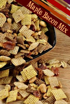 two black bowls filled with chex mix on top of a wooden table next to each other