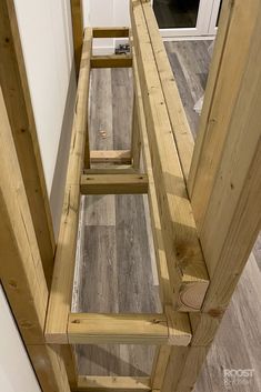 there is a wooden stair case on the floor in this house with wood floors and white walls