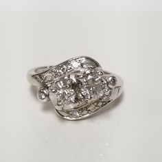 an antique diamond ring on a white surface with some diamonds in the center and two smaller stones at the bottom