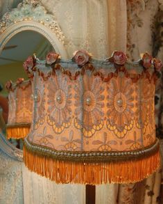 a lamp shade with flowers on it in front of a mirror