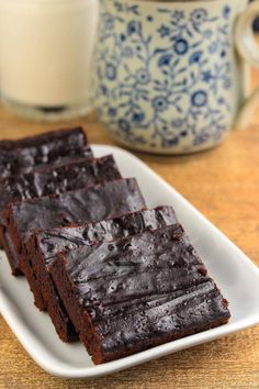 chocolate brownies on a plate next to a glass of milk