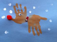 a handprinted reindeer with a red pom - pom on it