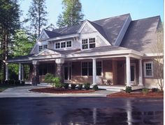 a large house with columns on the front and porches, along with two car garages