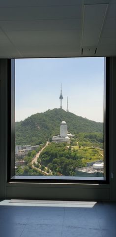 the view from inside an office building looking out onto a city with mountains in the background