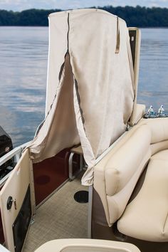 the back end of a boat with a cover on it's seat and console