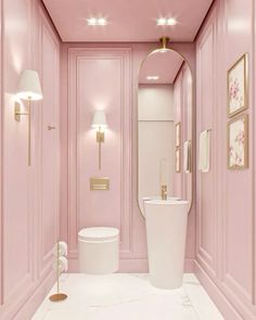 a bathroom with pink walls and white flooring, gold trimming on the wall