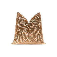 a brown and white pillow with an abstract design on the front, sitting on a white surface