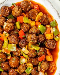 meatballs and vegetables are in a red sauce