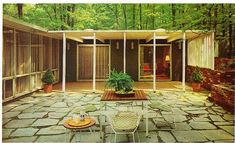 an outdoor patio with chairs and tables surrounded by trees