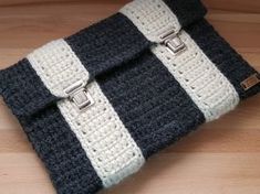 a black and white crocheted purse sitting on top of a wooden table next to a pair of scissors