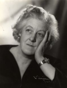 an old black and white photo of a woman with her hand on her head, looking at the camera