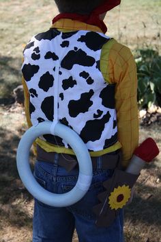 a young boy wearing a costume made to look like a cow with a ring around his neck