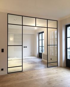 an empty room with glass doors and wood flooring