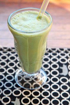 a green smoothie in a glass with a straw