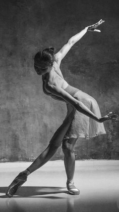 a black and white photo of a ballerina in the middle of a dance pose